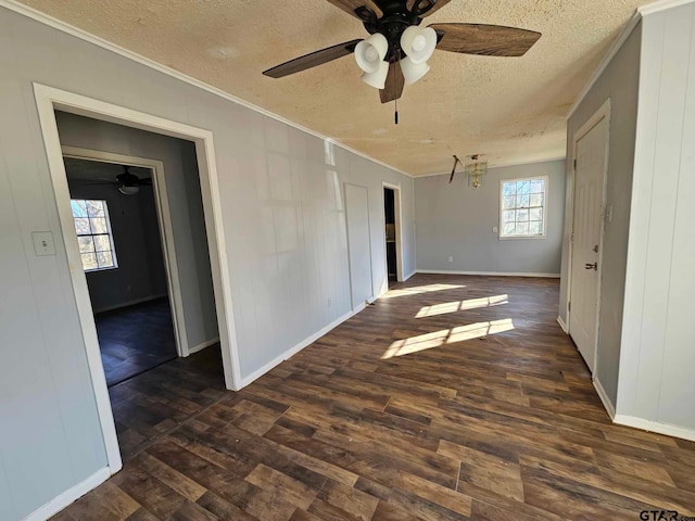 spare room featuring dark hardwood / wood-style flooring, ceiling fan with notable chandelier, a textured ceiling, crown molding, and wood walls