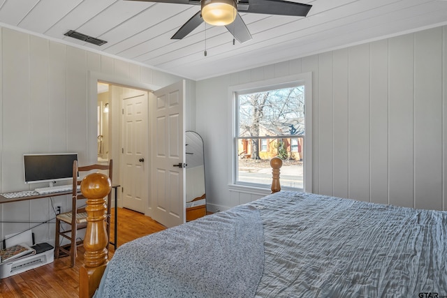 bedroom featuring ceiling fan, wood finished floors, and visible vents