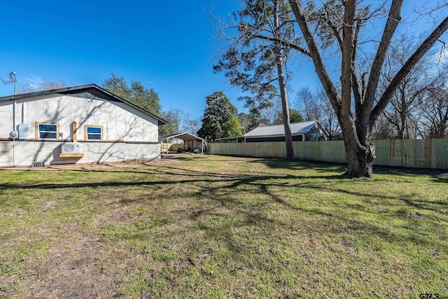 view of yard with a carport and fence