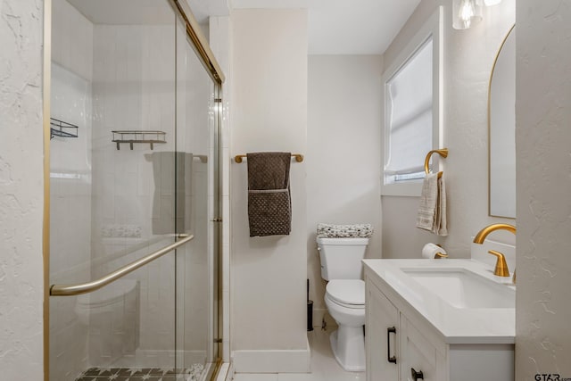 full bath with toilet, a shower stall, baseboards, and vanity