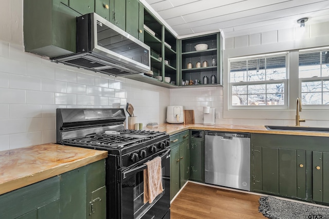 kitchen featuring open shelves, wooden counters, green cabinets, appliances with stainless steel finishes, and light wood-style floors