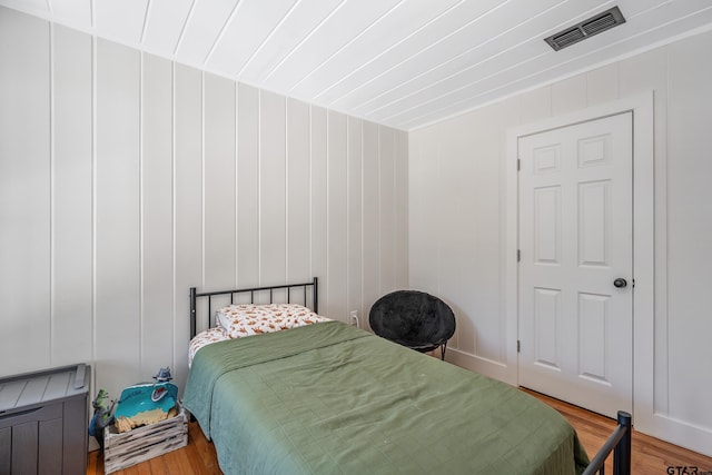 bedroom featuring visible vents and wood finished floors