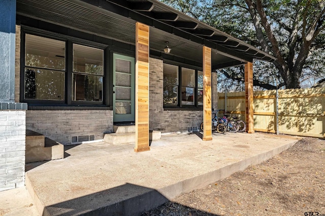 view of patio / terrace with entry steps, fence, and visible vents