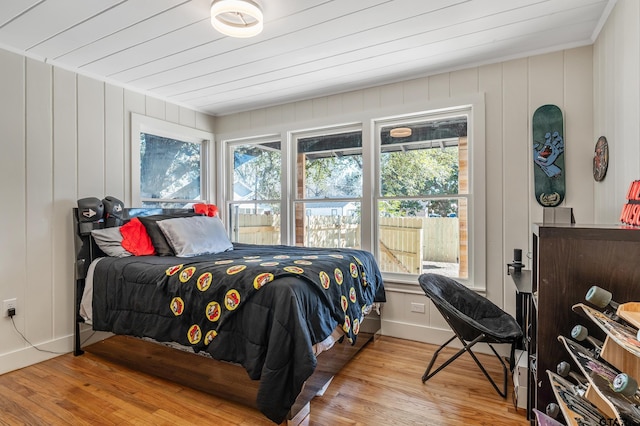 bedroom featuring light wood finished floors, wooden ceiling, and baseboards