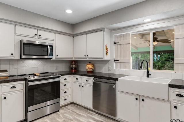 924 Bradley Dr, Athens, TX 75751 - kitchen with light wood-style floors, tasteful backsplash, white cabinets, and appliances with stainless steel finishes