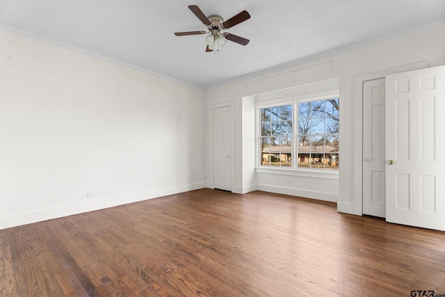 empty room with crown molding, ceiling fan, and dark hardwood / wood-style floors