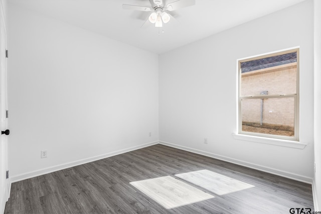 empty room featuring baseboards, dark wood-type flooring, and ceiling fan