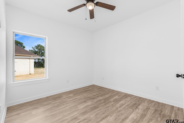 empty room featuring ceiling fan, baseboards, and wood finished floors