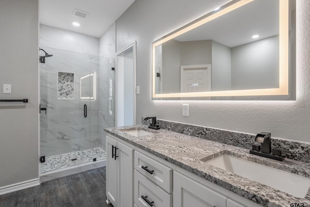 bathroom with wood-type flooring, vanity, and walk in shower