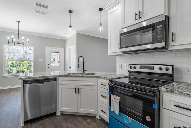 kitchen with white cabinetry, pendant lighting, light stone counters, and appliances with stainless steel finishes