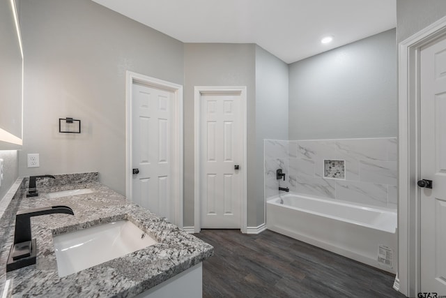 bathroom with a washtub, wood-type flooring, and vanity