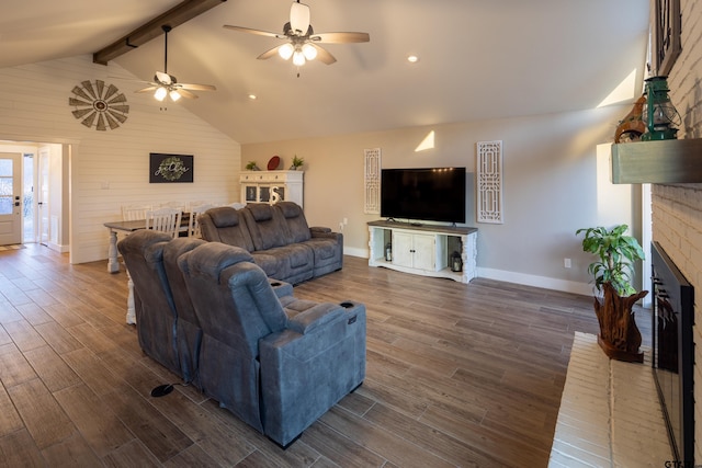 living room featuring vaulted ceiling with beams and a fireplace