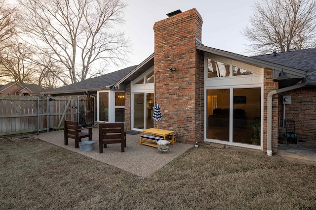 back of property featuring a patio, a sunroom, and a lawn