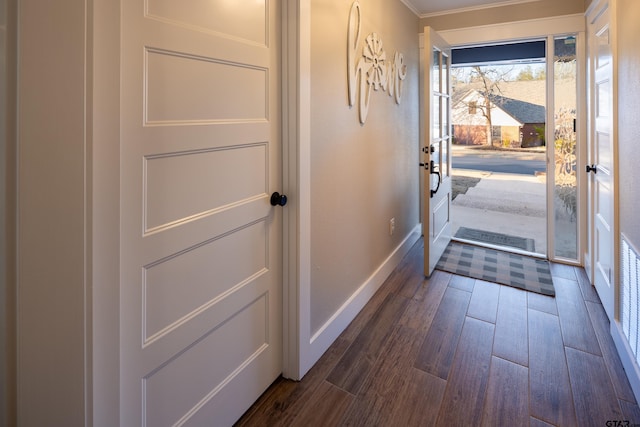 entryway featuring dark wood-type flooring and crown molding