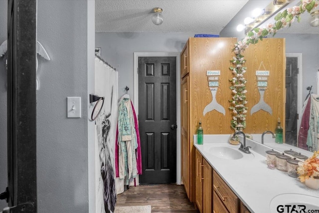 12305 Pine St, Larue, TX 75770 - full bathroom with wood finished floors, a sink, a textured ceiling, and double vanity