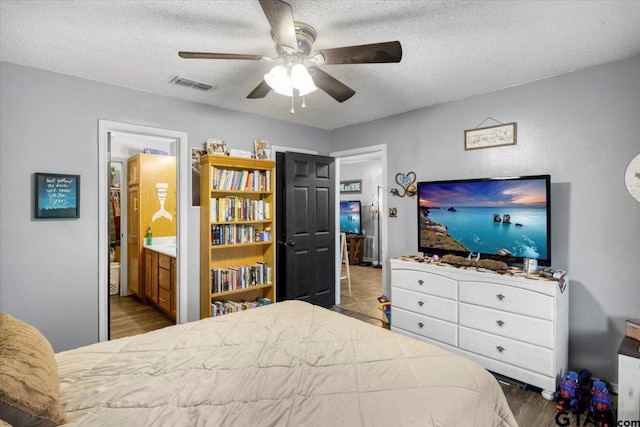 12305 Pine St, Larue, TX 75770 - bedroom with a textured ceiling, wood finished floors, visible vents, and a ceiling fan