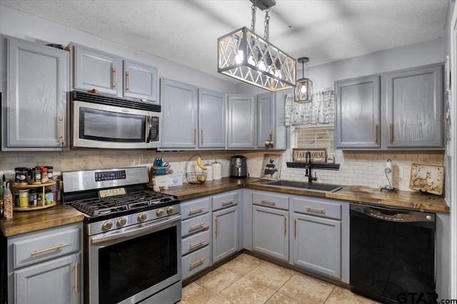 12305 Pine St, Larue, TX 75770 - kitchen with wooden counters, gray cabinetry, stainless steel appliances, and a sink
