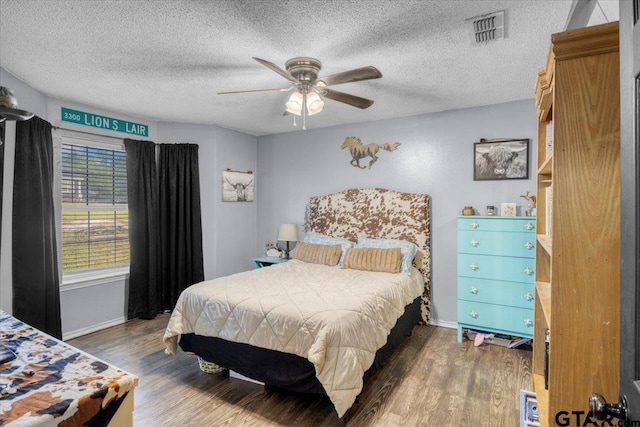 12305 Pine St, Larue, TX 75770 - bedroom featuring baseboards, wood finished floors, a textured ceiling, and visible vents