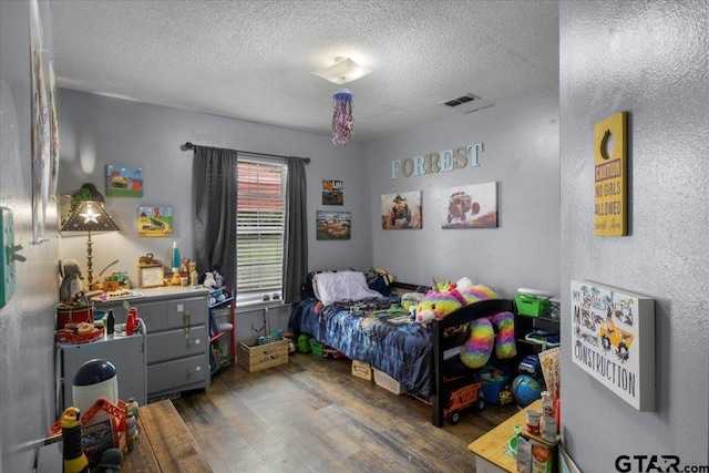 12305 Pine St, Larue, TX 75770 - bedroom featuring visible vents, wood finished floors, and a textured ceiling