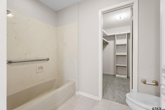 bathroom featuring bathing tub / shower combination, tile patterned flooring, a textured ceiling, and toilet