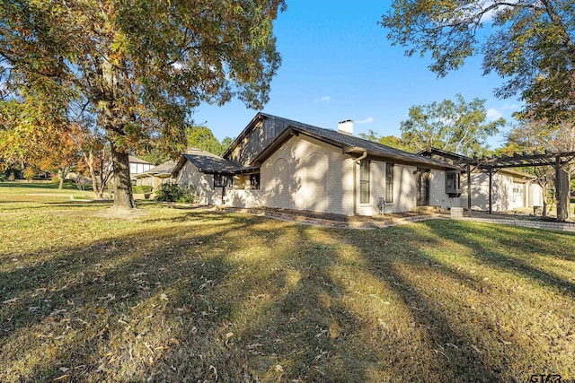 view of front facade with a front yard and a pergola