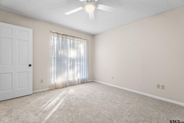 spare room featuring a textured ceiling, ceiling fan, and light carpet