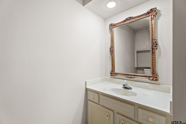 bathroom featuring a textured ceiling and vanity