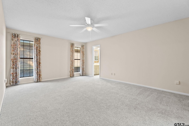 empty room with light carpet, ceiling fan, and a textured ceiling