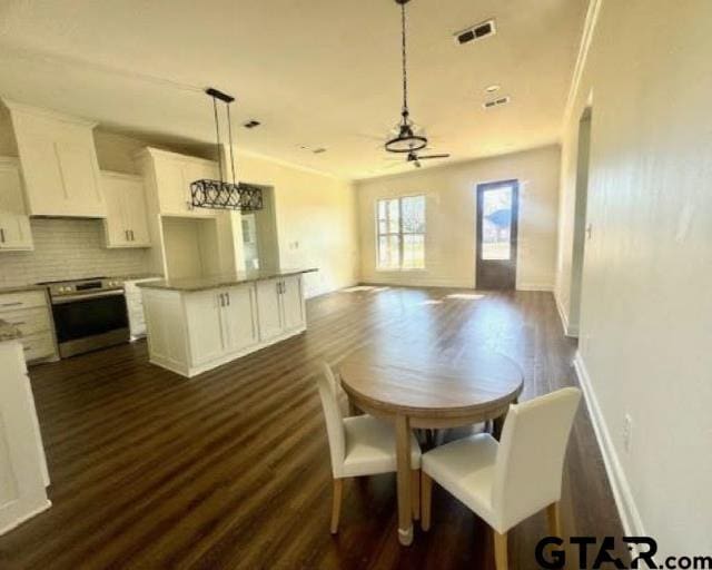 dining space featuring ceiling fan and dark wood-type flooring