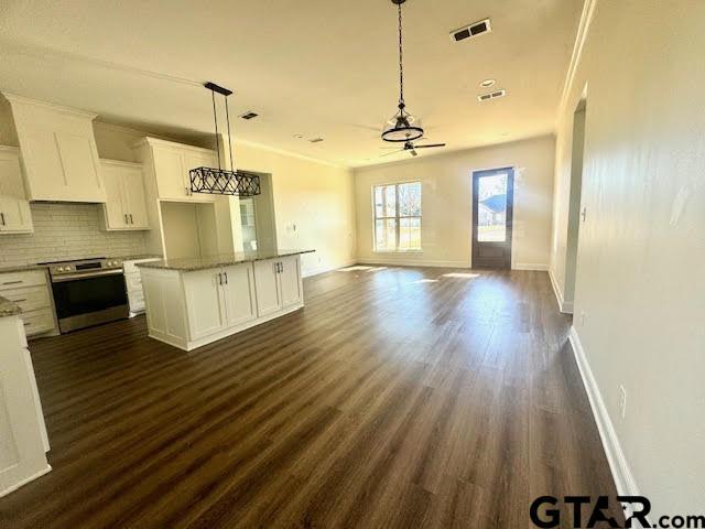 kitchen featuring backsplash, stainless steel electric stove, hanging light fixtures, a kitchen island, and white cabinetry