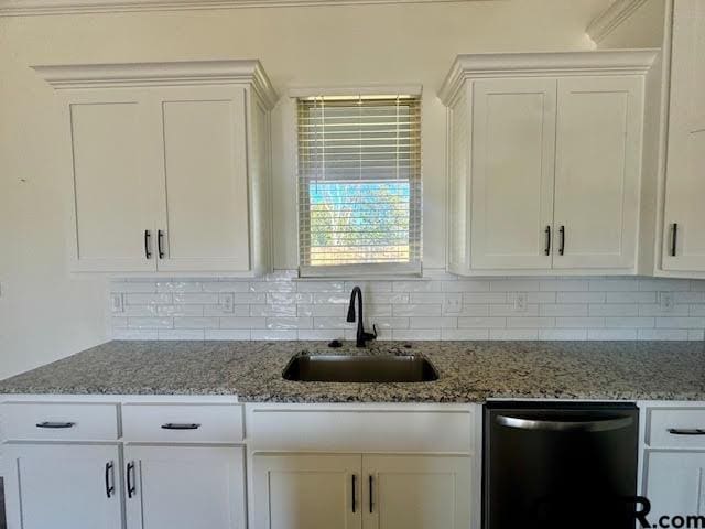 kitchen with white cabinetry, dishwasher, stone counters, sink, and decorative backsplash