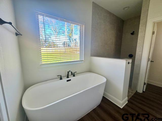 bathroom with hardwood / wood-style floors and separate shower and tub