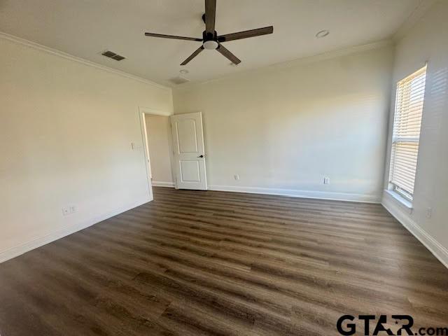 empty room featuring ceiling fan, dark hardwood / wood-style flooring, and ornamental molding