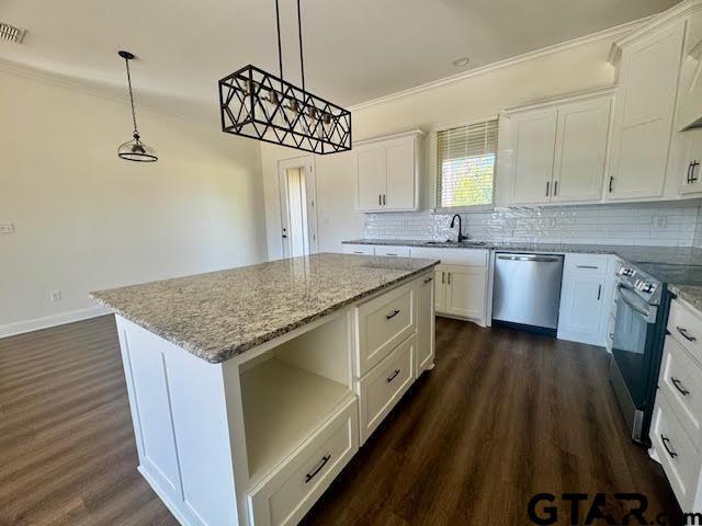 kitchen featuring pendant lighting, a center island, white cabinets, and stainless steel appliances