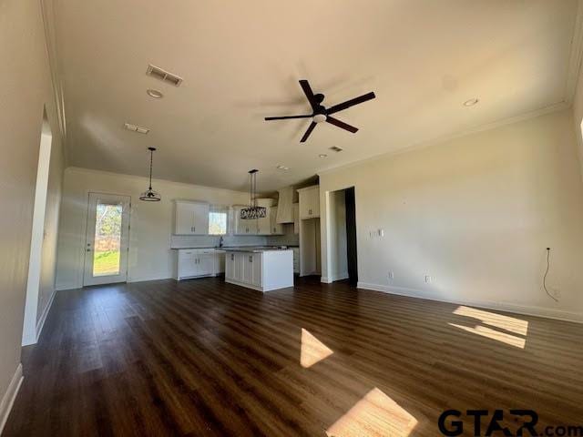 unfurnished living room with dark hardwood / wood-style floors, ceiling fan, and ornamental molding