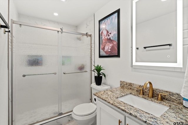 bathroom with vanity, an enclosed shower, and toilet