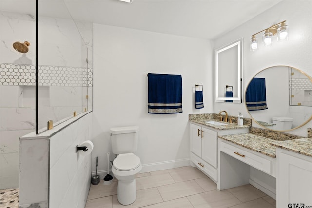 bathroom with tile patterned flooring, a tile shower, vanity, and toilet