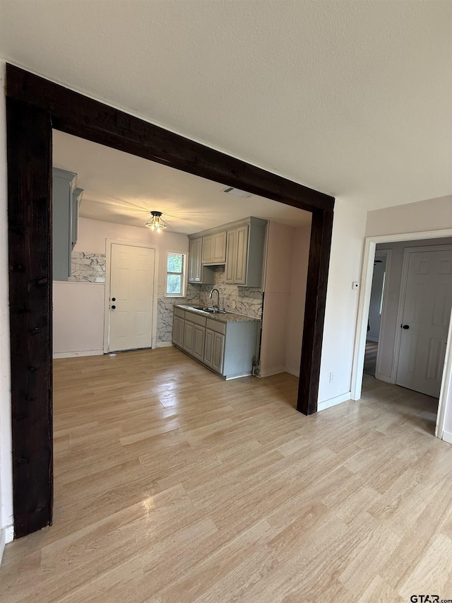 2907 Cushing Dr, Tyler, TX 75702 - kitchen featuring gray cabinetry, light wood finished floors, tasteful backsplash, a textured ceiling, and beam ceiling