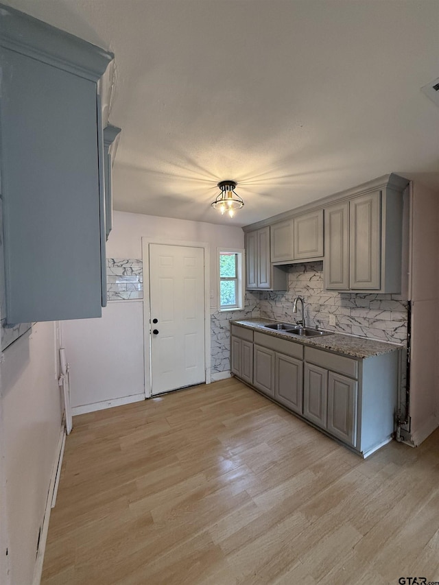 2907 Cushing Dr, Tyler, TX 75702 - kitchen featuring gray cabinetry, light wood-style floors, and backsplash