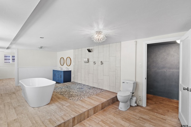 4456 Fm 2767, Tyler, TX 75708 - bathroom featuring a notable chandelier, toilet, tiled shower, a freestanding tub, and wood finished floors