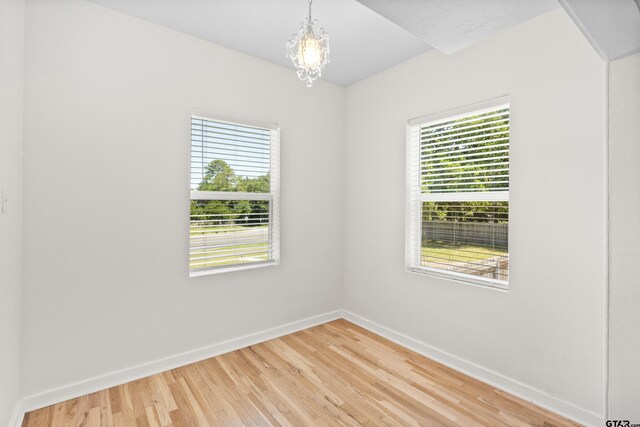 4456 Fm 2767, Tyler, TX 75708 - spare room featuring plenty of natural light, baseboards, a chandelier, and light wood finished floors