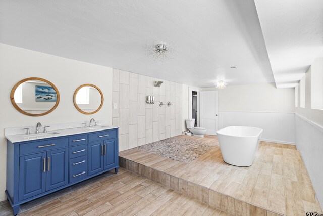 4456 Fm 2767, Tyler, TX 75708 - bathroom featuring wood finished floors, double vanity, a tile shower, and a freestanding bath