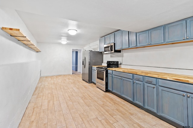 4456 Fm 2767, Tyler, TX 75708 - kitchen featuring appliances with stainless steel finishes, wood counters, blue cabinets, and light wood-style floors