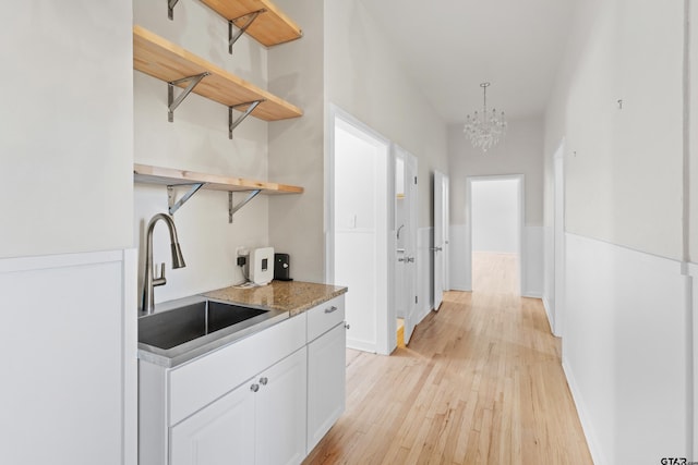 4456 Fm 2767, Tyler, TX 75708 - kitchen featuring a sink, open shelves, light wood-style flooring, a chandelier, and white cabinetry