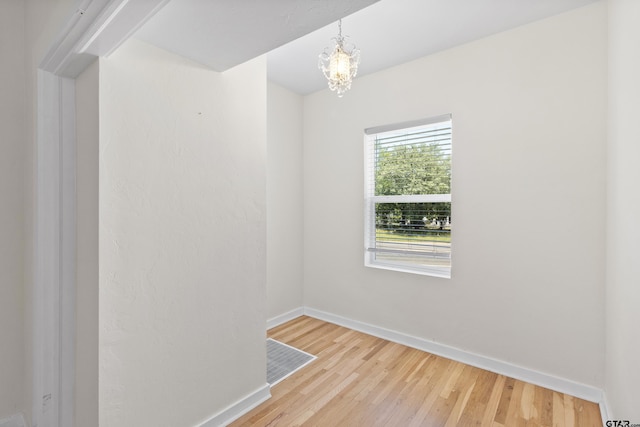 4456 Fm 2767, Tyler, TX 75708 - empty room featuring a notable chandelier, baseboards, and wood finished floors