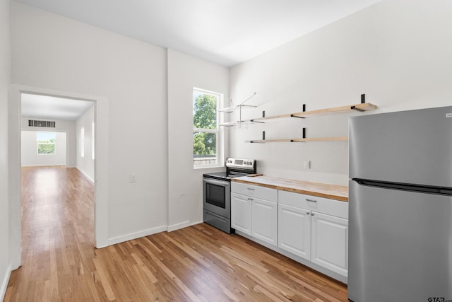 4456 Fm 2767, Tyler, TX 75708 - kitchen with appliances with stainless steel finishes, light wood finished floors, open shelves, white cabinets, and wood counters