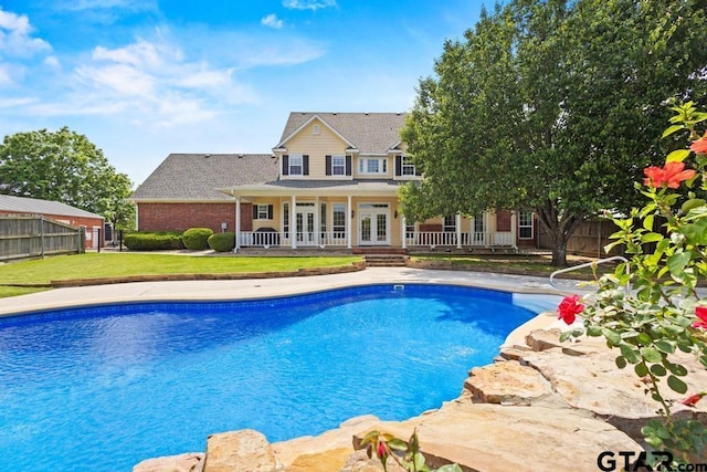 view of pool featuring a yard, a fenced in pool, french doors, and fence