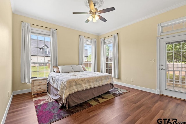 bedroom featuring baseboards, wood finished floors, access to outside, and multiple windows