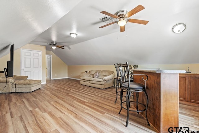 additional living space featuring lofted ceiling, visible vents, ceiling fan, and light wood-style flooring