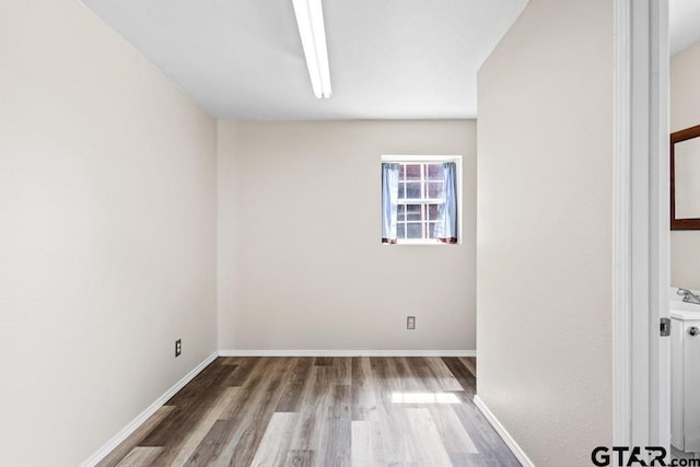 empty room with baseboards and wood finished floors